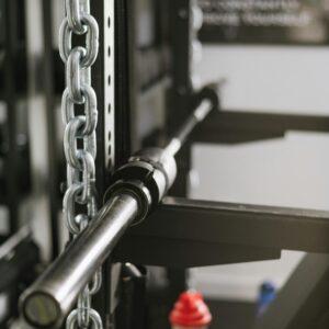 Close-up view of gym equipment including chains and a barbell, ideal for weightlifting and bodybuilding.