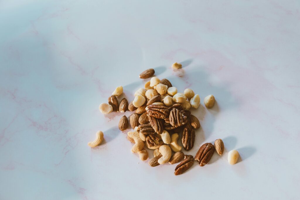 Close-up of assorted nuts on a marble surface, with natural lighting and texture.